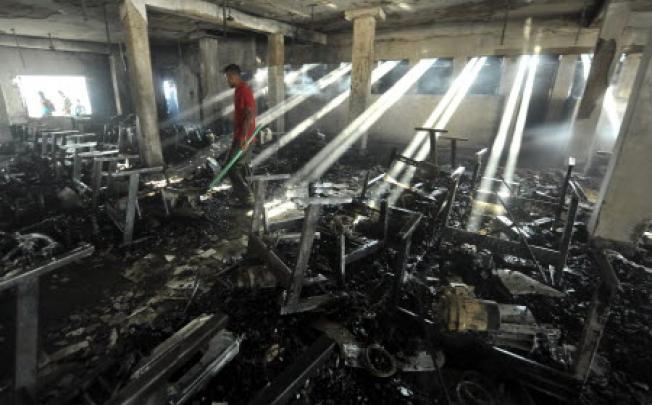People look for things to salvage after a fire at the Smart Fashions garment factory in Dhaka on Saturday. Photo: Reuters