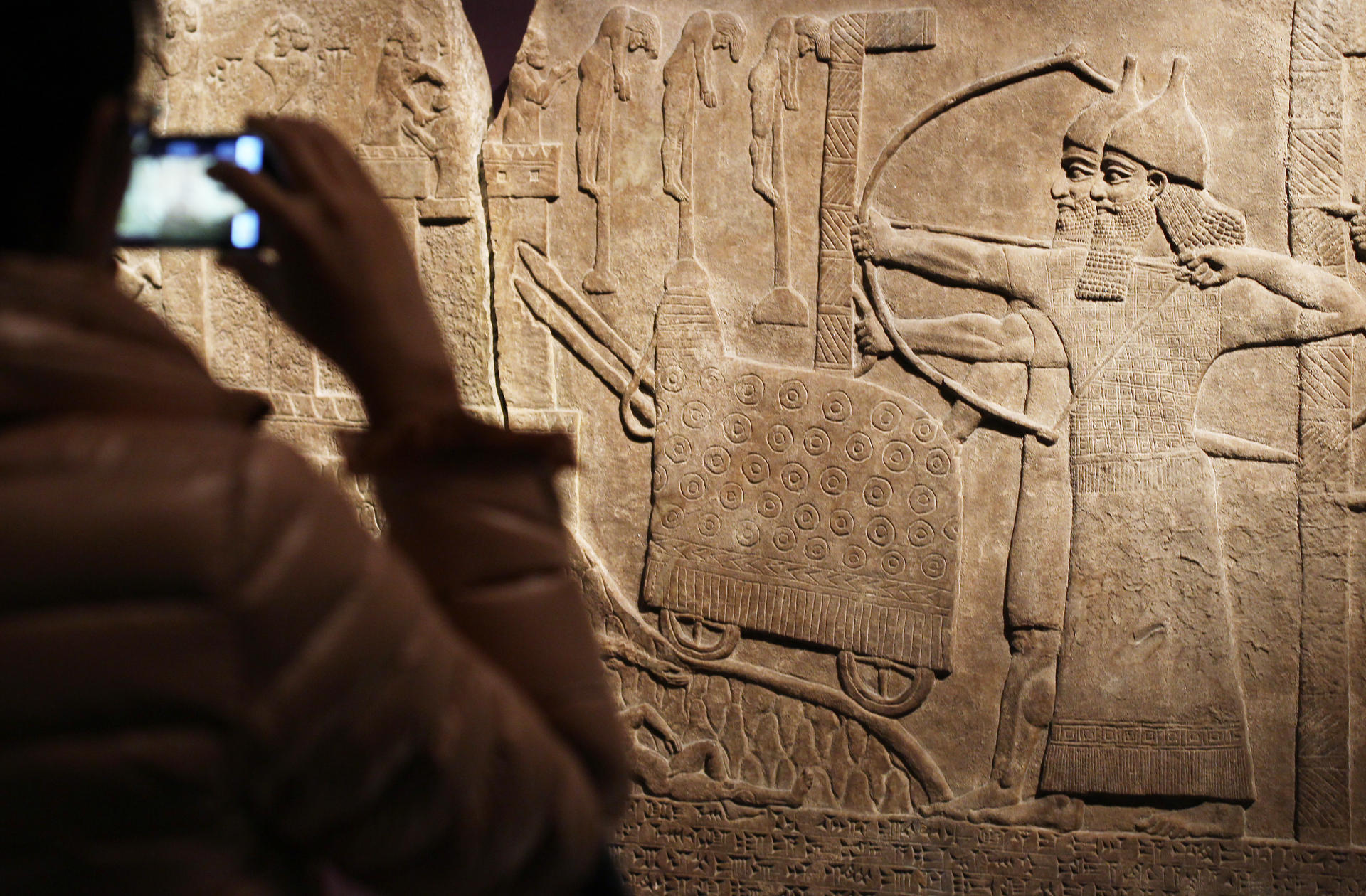 A visitor photographs the wall relief “Attack on an enemy town” of an Assyrian assault on a town in Turkey in 738-737BC. Photo: Sam Tsang