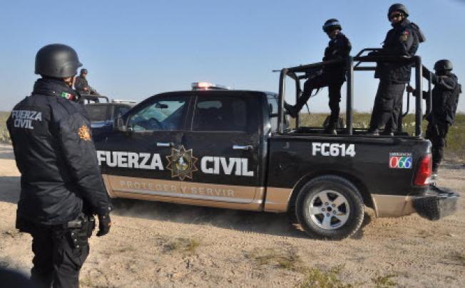 Nuevo Leon state police stand guard near the town of Mina, in northern Mexico on Monday. Several bodies were found in a well near this ranch. Photo: AP 