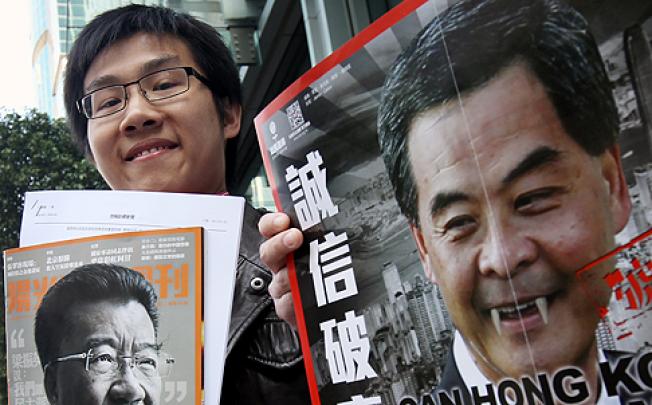 Raphael Wong Ho-ming with photos of Lew Mon-hung, left, and Leung Chun-ying, right, before entering the ICAC headquarters in North Point on Wednesday.  Photo: David Wong