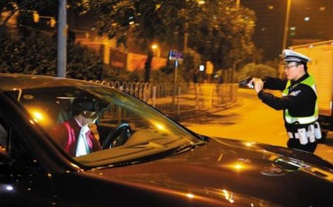 A traffic patrol policeman in Guangzhou pointed a gun at a speeding driver. Picture: SCMP/ Yangcheng