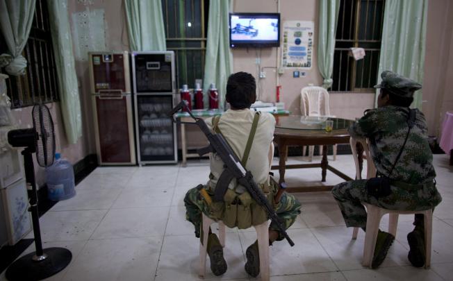 Kachin Independent Army (KIA) soldiers watch a TV program at a restaurant in the town of Laiza, in northern Myanmar's Kachin-controlled region. Photo: AP