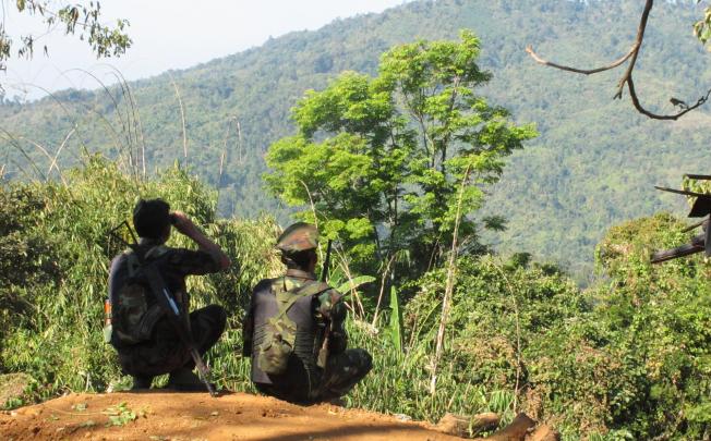 Two Kachin fighters look across at Hka Ya mountain from one of their last outposts as the relentless daily bombardments around Laiza by government forces continued two weeks ago. Photo: Steve Tickner