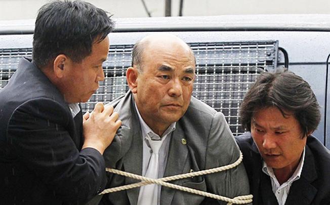 Ro Su-hui is led away tied up and cuffed by South Korean security guards. Photo: AP
