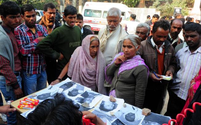 Relatives view photos of the dead at a morgue in Allahabad. Photo: AFP