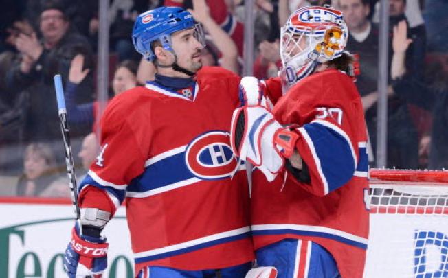 Tomas Plekanec #14 and Peter Budaj #30 of the Montreal Canadiens celebrate after defeating the Carolina Hurricanes in Montreal. Photo: AFP