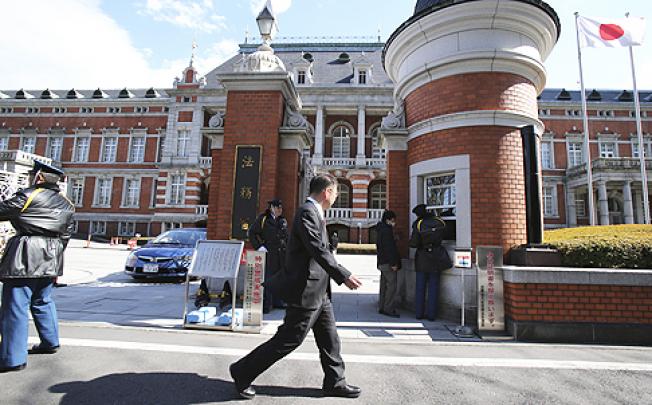 A man walks in front of the Justice Ministry in Tokyo. The ministry said Japan executed three inmates convicted of murder early on Thursday. Photo: AP