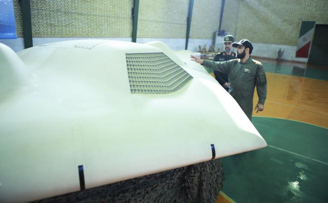 A revolutionary guard pointing to a US RQ-170 drone captured by Iran, in December 2011. Photo: Reuters