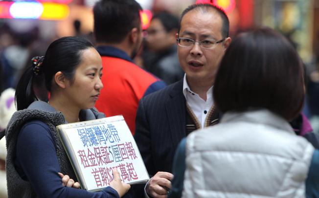 A property agent (left) speaking to prospective buyers of commercial shops in Great George Street, Causeway Bay. Photo: Dickson Lee