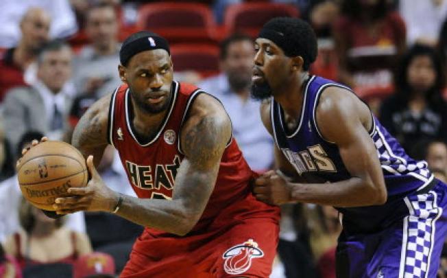 Miami Heat's LeBron James (left) is defended by Sacramento Kings' John Salmons (right) during overtime of their NBA basketball game in Miami, Florida. Photo: Reuters.