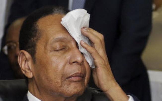 Former Haitian dictator Duvalier wipes sweat from his brow during an appeals court hearing in Port-au-Prince. Photo: Reuters