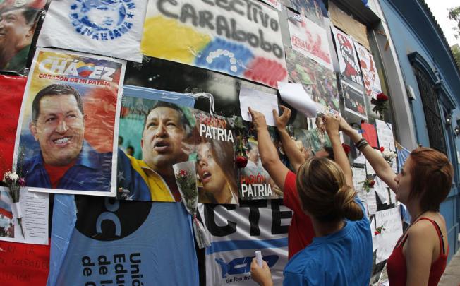 People place messages of condolences on a wall during a rally honouring late Venezuelan President Hugo Chavez. Photo: Reuters