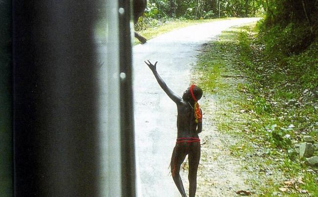 A Jarawa tribesman seeks handouts from a bus on the Andaman Trunk Road, which is due to officially reopen. Photo: AFP 