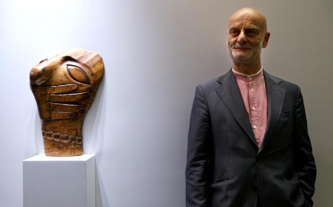 Swiss collector Dr Uli Sigg donates HK$1.3 billion worth of artworks to the West Kowloon Cultural District Authority. He poses with Wang Keping's wooden sculpture Chain. Photo: Sam Tsang