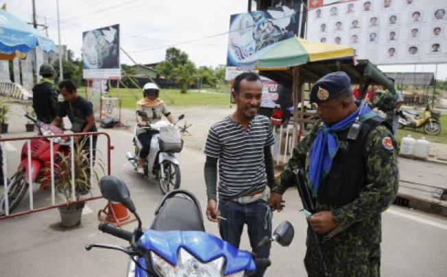 People are searched by soldiers at a checkpoint in the southern Narathiwat province. Thailand and one of several rebel groups in the country’s Muslim south will open peace negotiations in Malaysia later this month. Photo: EPA