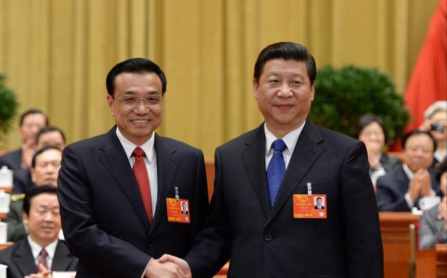 Li Keqiang shakes hands with Xi Jinping in Beijing on March 15, 2013. Photo: Xinhua