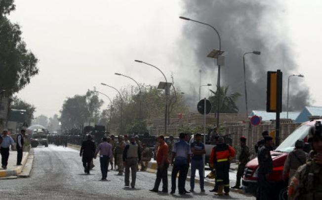 Smoke billows from the scene of a car bomb attack in Baghdad. A string of bombings on a ministry near Baghdad's Green Zone killed 18 people. Photo: AFP