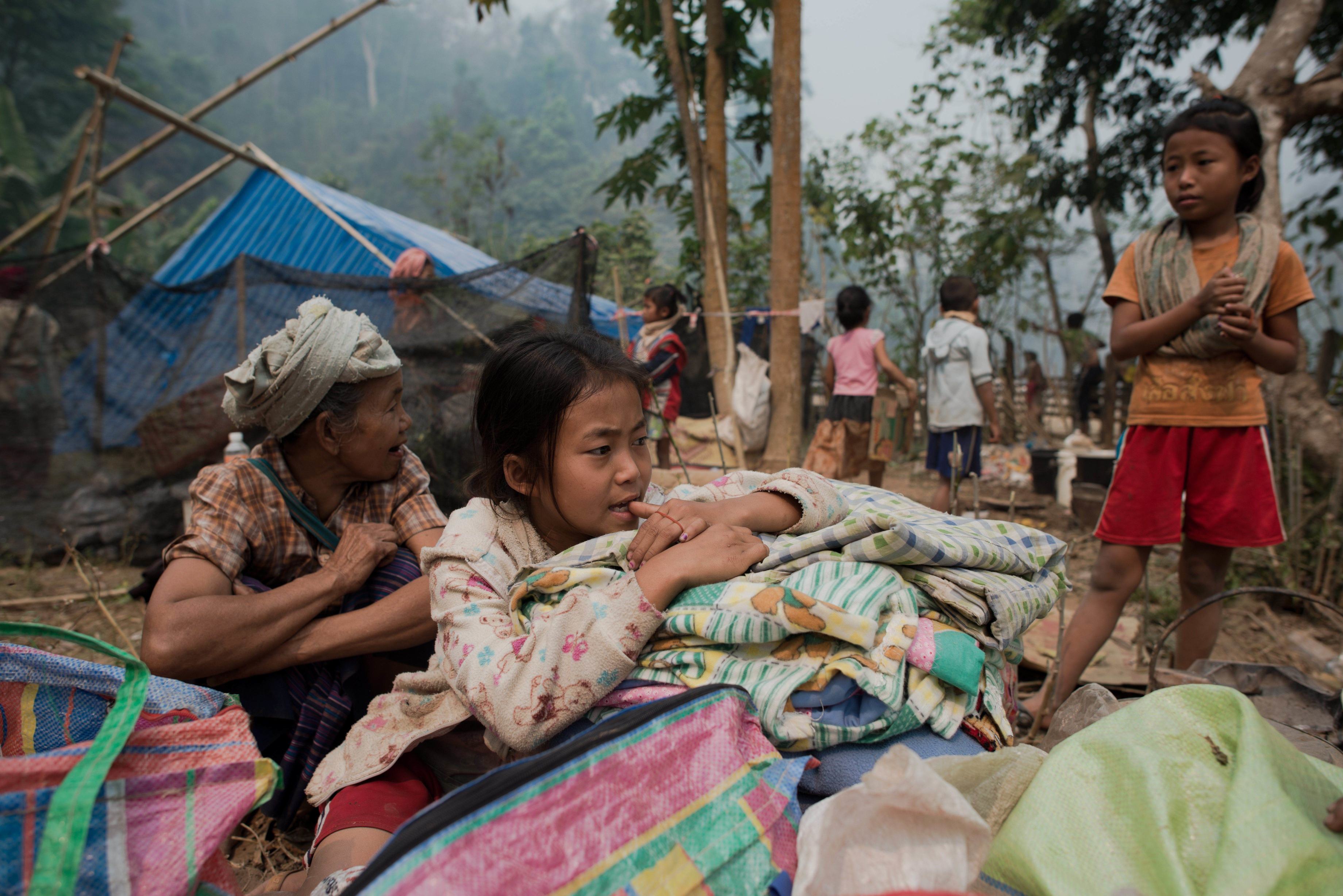 Myanmar refugees sit with their belongings as they start to build temporary shelters with bamboo and leaves at the Mae Surin camp in Mae Hong Son province, northern Thailand. Photo: AFP