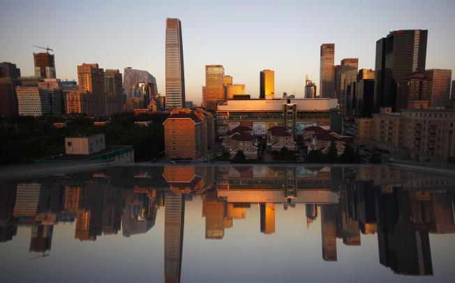 Office and residential buildings are reflected in a window in Beijing's central business district.  Photo: Reuters