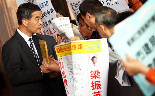 Chief Executive Leung Chun-ying receives a package from protesters at government headquarters in Admiralty yesterday. Photo: Sam Tsang