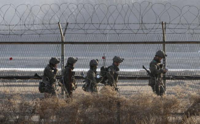 South Korean army soldiers patrol along a barbed-wire fence near the border village of Panmunjom in Paju in South Korea. Photo: AP