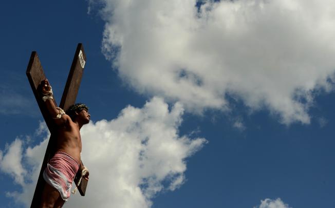 A penintent is nailed to a cross during the reenactment of crucifixion on Good Friday in the village of San Juan, San Fernando City, north of Manila. Photo: AFP