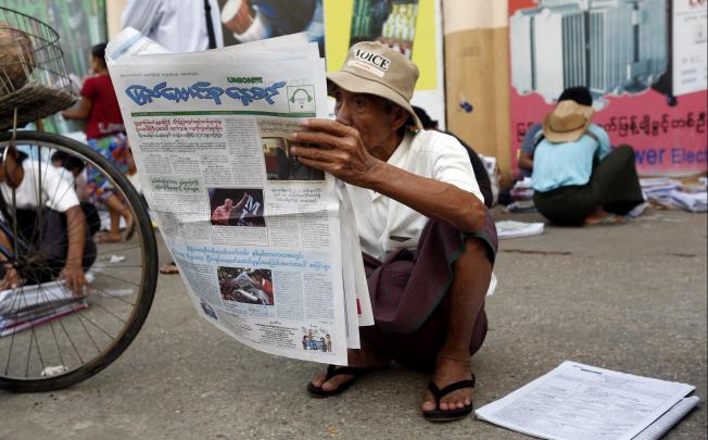 A man reads a newspaper on the roadside in Yangon, Myanmar, on Monday. Photo: Xinhua