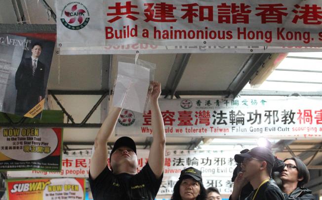 A Food and Environmental Hygiene Department official puts up a letter demanding the banners' removal. Photo: Felix Wong