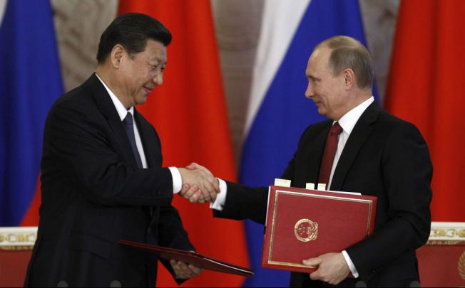 Russia's President Vladimir Putin (right) exchanges documents with Xi Jinping during a signing ceremony at the Kremlin in Moscow. Photo: Reuters