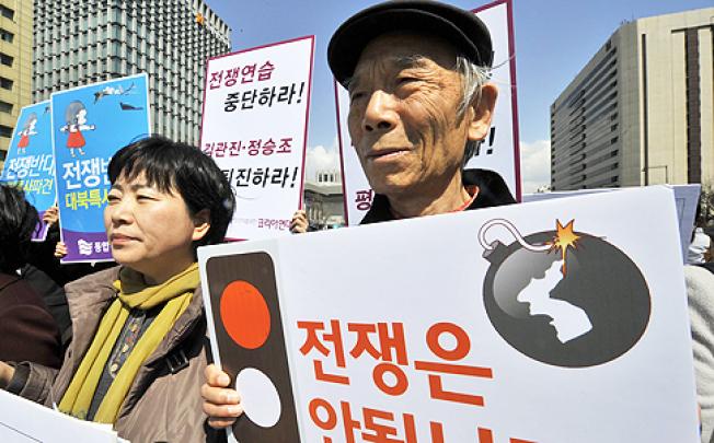 South Korean activists hold placards reading "We oppose war!" during an anti-war rally urging peace talks with North Korea in Seoul on Tuesday. Photo: AFP