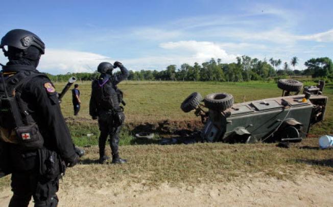 Thai security forces inspect the site of a roadside bomb attack on an armoured vehicle by suspected separatist militants which killed two soldiers and injured six in Thailand's restive southern province of Pattani. Photo: AFP