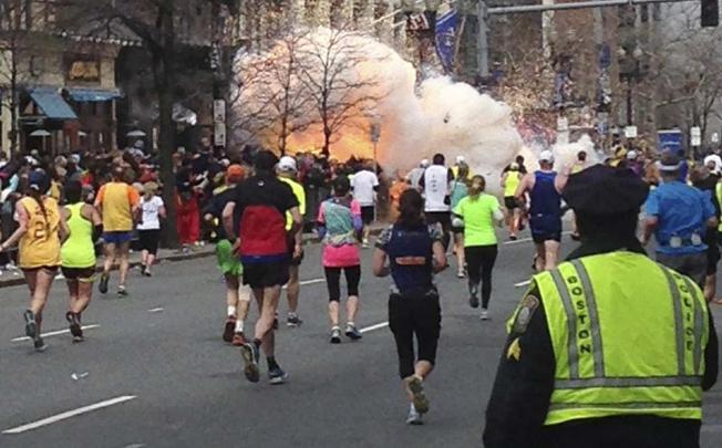 Runners approach the finishing line in the Boston Marathon as a bomb goes off, sending up a huge cloud of smoke. Photo: Reuters