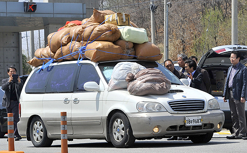 South Korean representatives of the business companies at Kaesong greet a car carrying sacks of clothes made in North Korea's Kaesong joint industrial complex on Wednesday. Photo: AFP