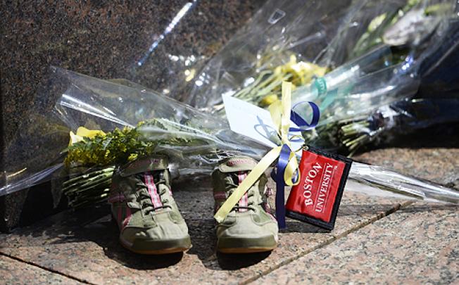 A pair of running shoes, flowers and a university key chain were left in front of a memorial to Martin Luther King as a tribute to the killed student. Photo: EPA