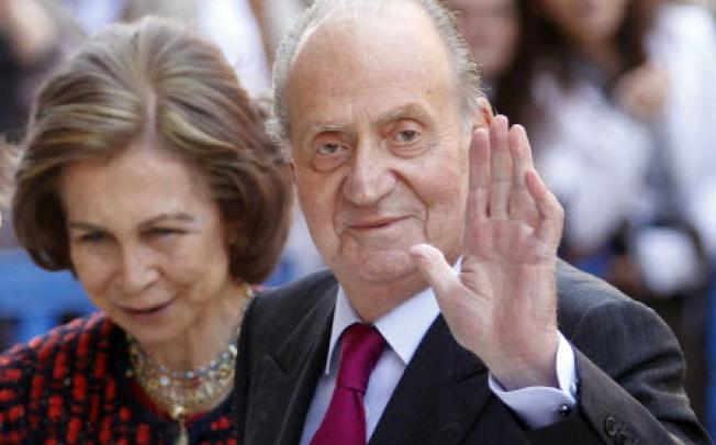 Spain's King Juan Carlos (right) waves beside Queen Sofia. Photo: Reuters