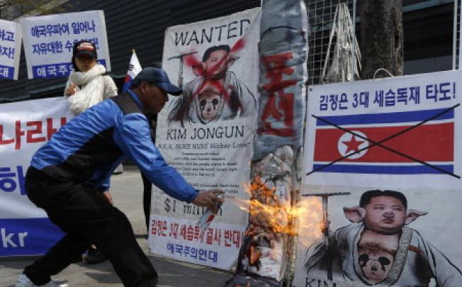 A South Korean protester burns banners with pictures of North Korean leader Kim Jong Un during an anti-North Korea protest rally in downtown Seoul, South Korea on Thursday. Photo: AFP