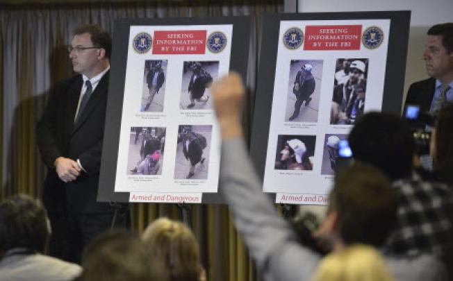  Photos of two suspects for the Boston Marathon bombings are seen during a press conference to release their photos and video in Boston. Photo: Xinhua.