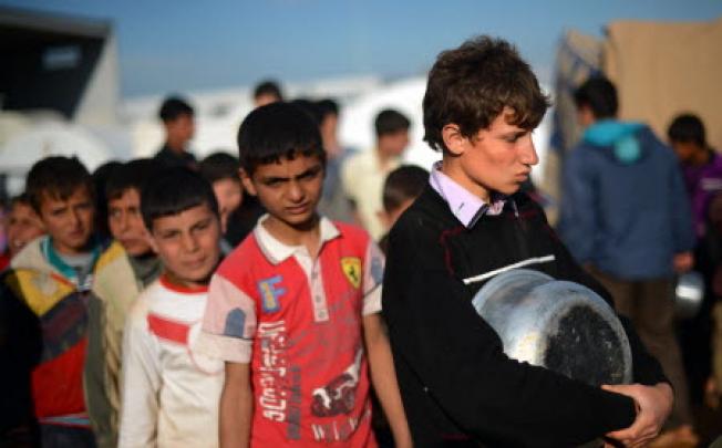 Displaced Syrian youths line up for food at a refugee camp in Aleppo. The UN says the Syrian conflict is a humanitarian catastrophe. Photo: AFP 