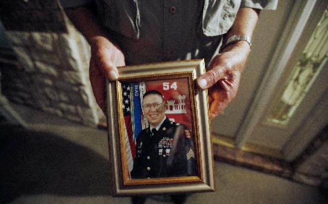 Wilburn Russell displays a portrait of his son, the Army sergeant who is accused of killing five fellow soldiers in Iraq. Photo: Reuters