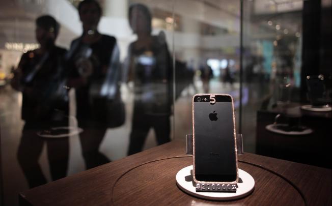 The custom-built iPhone 5 with a rose gold dressing on its chassis, topped off with 7.28 carats of diamonds, in a shop window display case at customised luxury goods store in Hong Kong. Photo: AFP