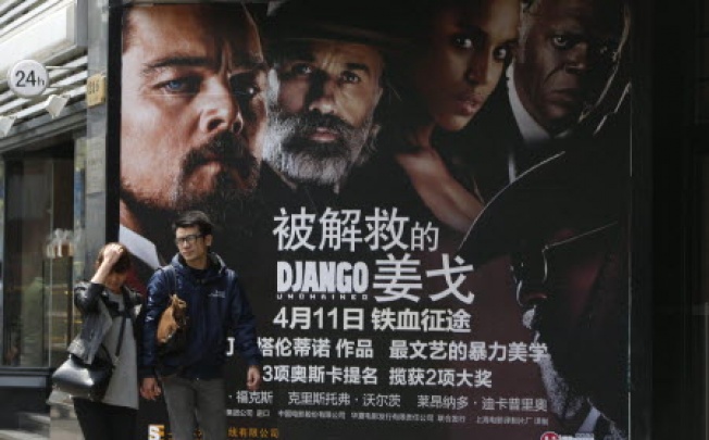 A Chinese couple walk past a movie poster of US movie 'Django Unchained' in Shanghai, China, 12 April 2013. Photo: EPA