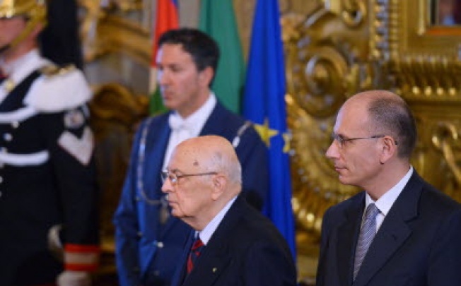 New Italian Prime Minister Enrico Letta (right) and President Giorgio Napolitano (centre) stand during the swearing in ceremony of the new government at the Quirinale Palace in Rome on Sunday. Photo: AFP