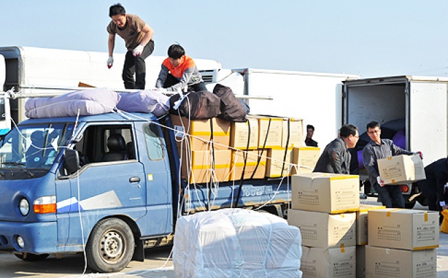 South Korean workers unload products made at the inter-Korean Kaesong Industrial Complex in North Korea, after the products arrived at at a military checkpoint in the border city of Paju, on Saturday. Photo: AFP