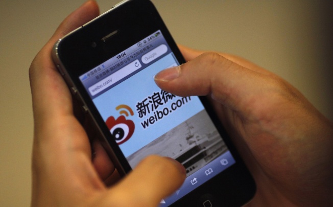 A man holds an iPhone as he visits Sina's Weibo microblogging site in Shanghai. Photo: Reuters