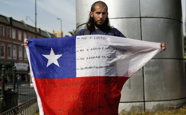 A student protester holds up a Chilean flag in Santiago. Photo: Reuters