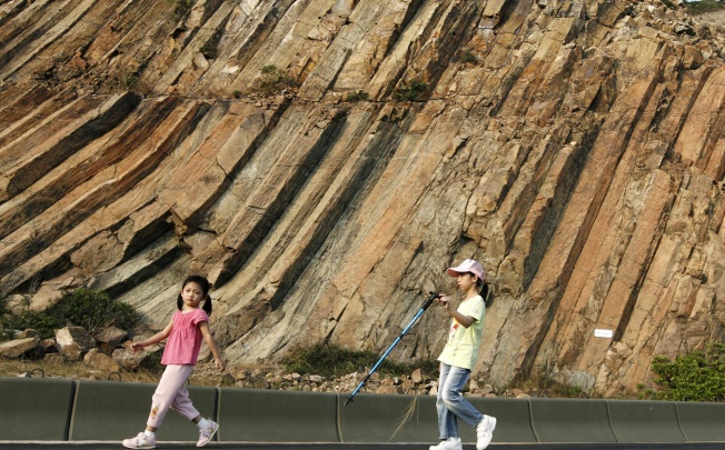 Children walk among hexagonal rocks in Sai Kung. Photo: May Tse