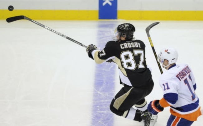 Pittsburgh Penguins' Sidney Crosby (87) juggles the puck past New York Islanders' Lubomir Visnovsky in the third period of their Stanley Cup playoffs Eastern Conference quarter-final game in Pittsburgh, Pennsylvania. Photo: Reuters