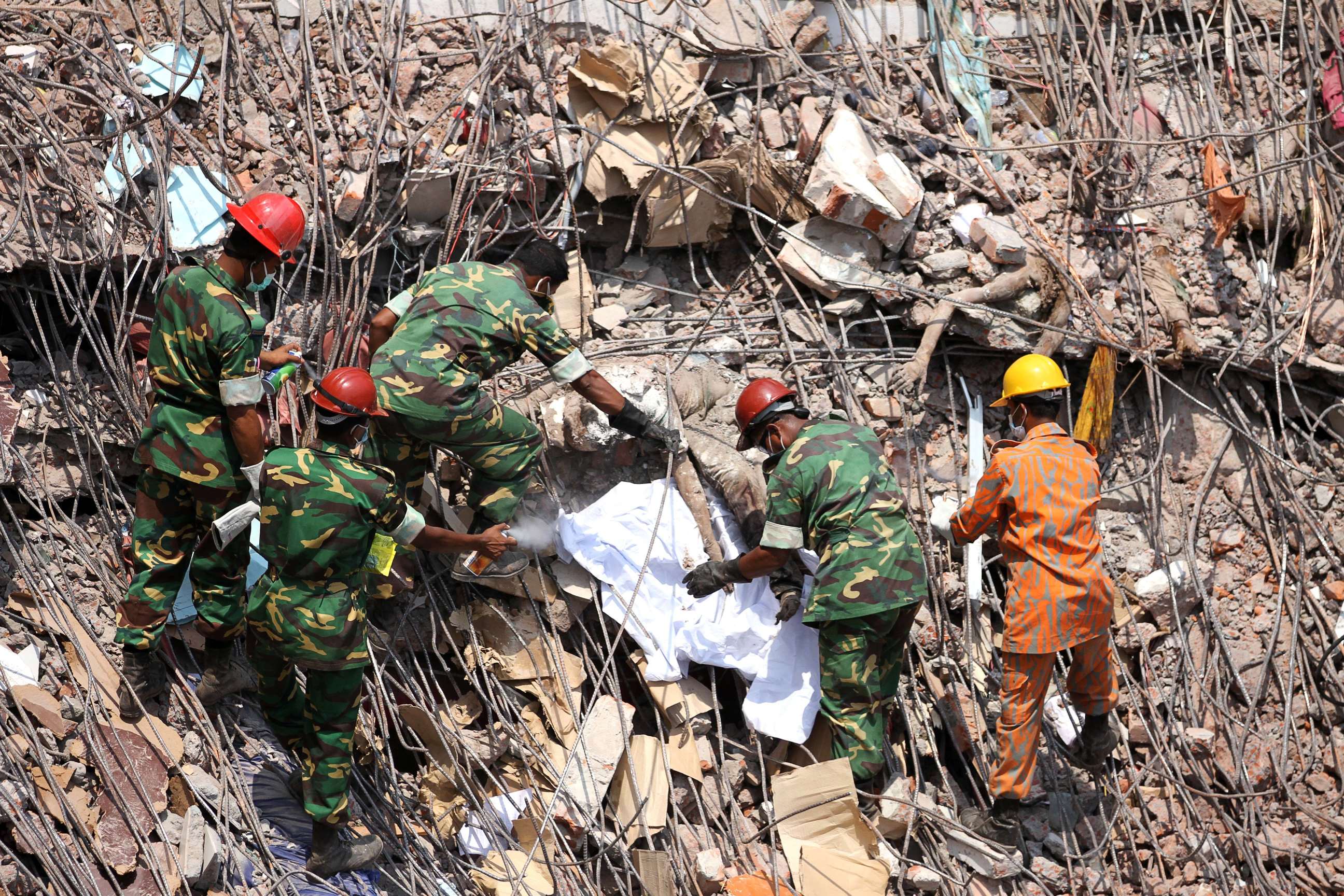 Rescuers work to dislodge decomposed bodies caught in the rubble of the collapsed Rana Plaza factory building near Dhaka, Bangladesh on Saturday. Photo: AP