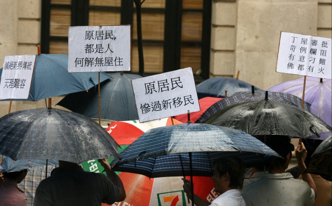 More than 100 angry New Territories indigenous residents of the New Territories hold their umbrellas under the rain and protest outside Legco Building about the small-house policy, Central. Photo: Martin Chan