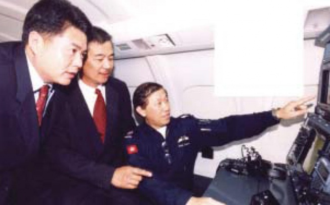 Timothy Tong (centre), of customs, takes Shenzhen customs director general Zou Zhiwu (left) on a GFS plane in 2004. Photo: SCMP